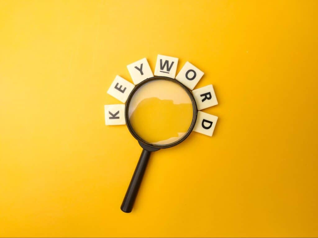 lettres du mot “Keyword’’ autour d’une loupe-recherche par mot-clé